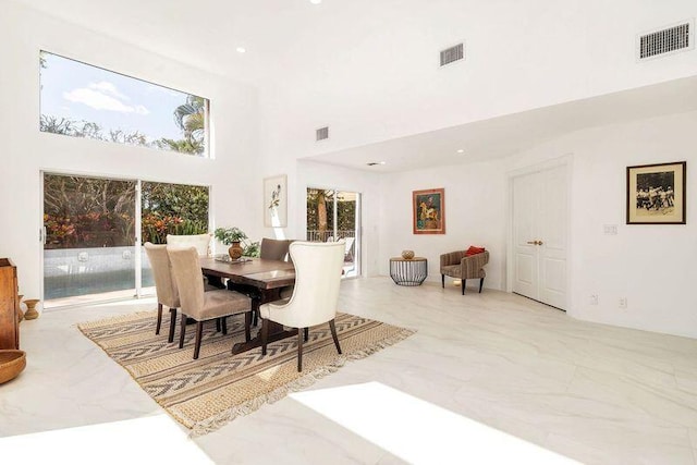 dining space featuring a towering ceiling