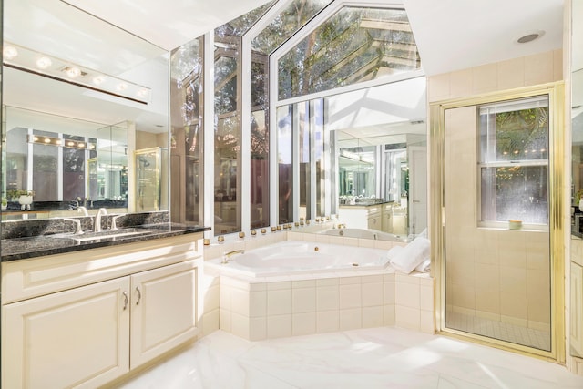 bathroom with vanity, independent shower and bath, and a wealth of natural light