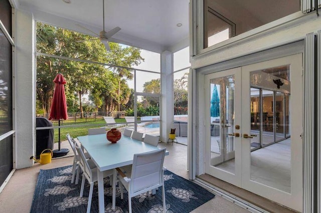 sunroom / solarium with ceiling fan, a wealth of natural light, and french doors