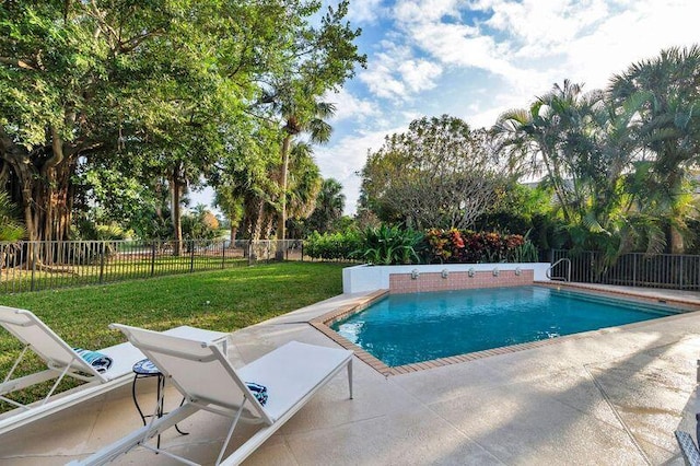 view of swimming pool with a patio area and a lawn