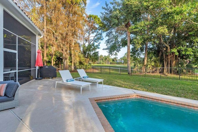 view of swimming pool with a lawn, a sunroom, area for grilling, and a patio