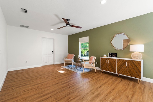 sitting room with ceiling fan and hardwood / wood-style flooring