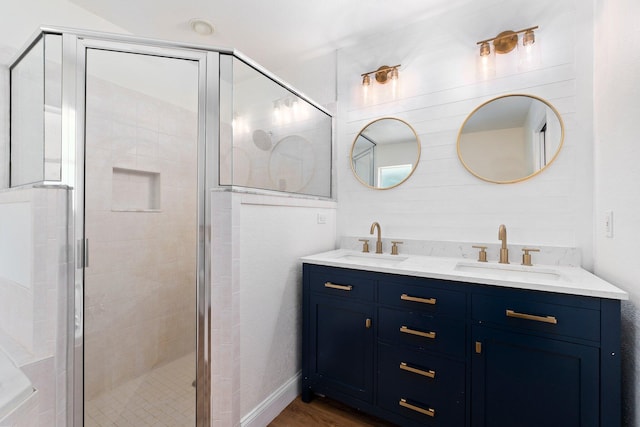 bathroom featuring wood-type flooring, wood walls, an enclosed shower, and dual vanity