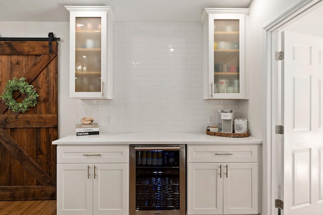 bar with white cabinets, tasteful backsplash, and beverage cooler