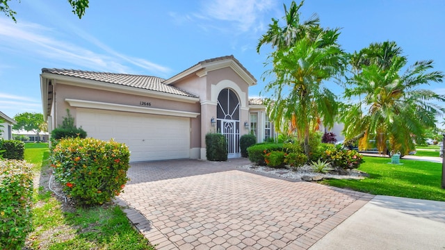 mediterranean / spanish-style home with a front lawn and a garage