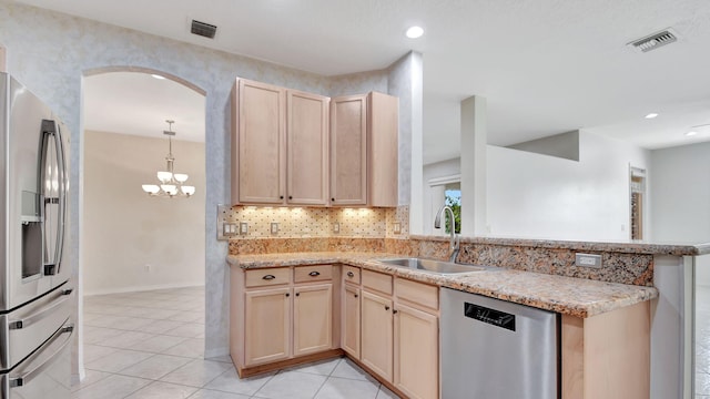 kitchen featuring sink, kitchen peninsula, light tile flooring, and appliances with stainless steel finishes