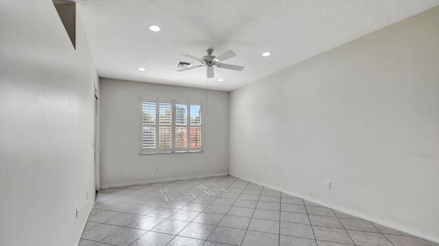 spare room featuring ceiling fan and light tile floors