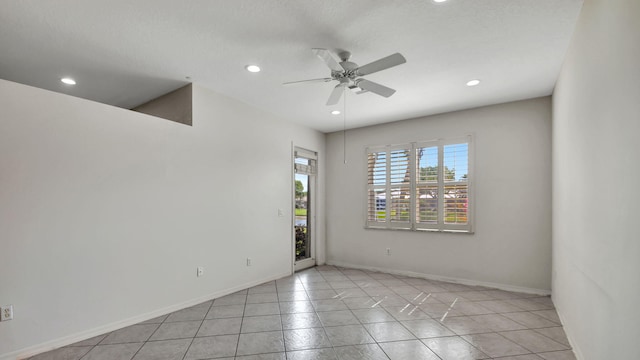 unfurnished room with ceiling fan and light tile floors