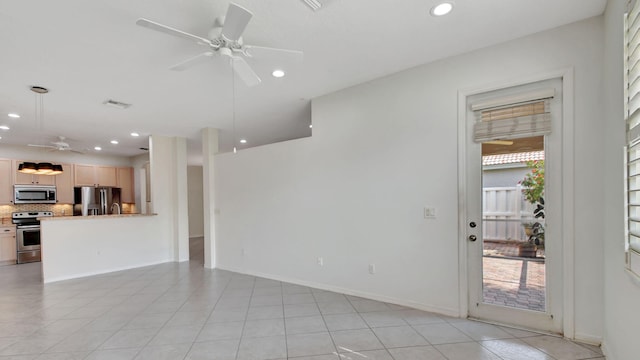 unfurnished living room with ceiling fan and light tile floors