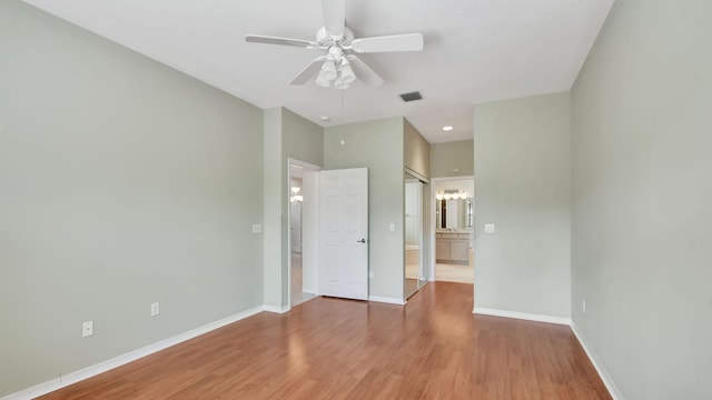 unfurnished bedroom featuring ceiling fan, a closet, connected bathroom, and wood-type flooring