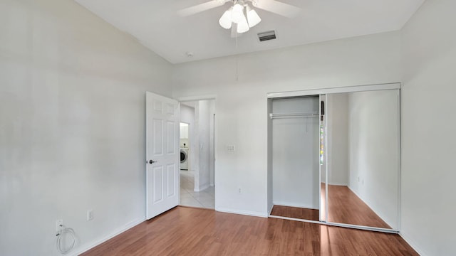 unfurnished bedroom featuring ceiling fan, tile flooring, a closet, and washer / dryer