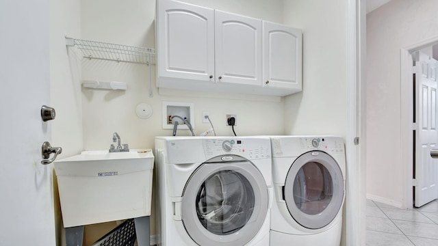 clothes washing area with light tile flooring, washer hookup, hookup for an electric dryer, washer and clothes dryer, and cabinets