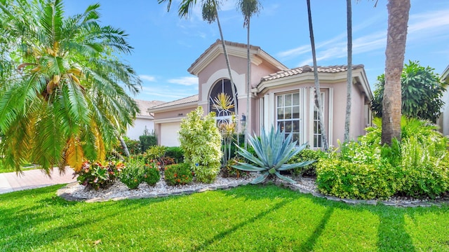 mediterranean / spanish-style home featuring a garage and a front yard