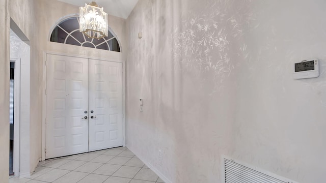 entrance foyer with an inviting chandelier and light tile flooring