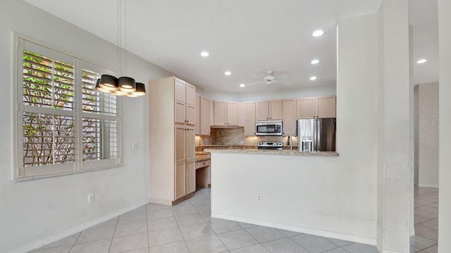 kitchen featuring light brown cabinets, kitchen peninsula, backsplash, appliances with stainless steel finishes, and light tile floors