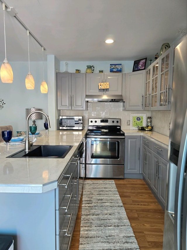 kitchen featuring gray cabinetry, stainless steel appliances, sink, pendant lighting, and dark hardwood / wood-style floors