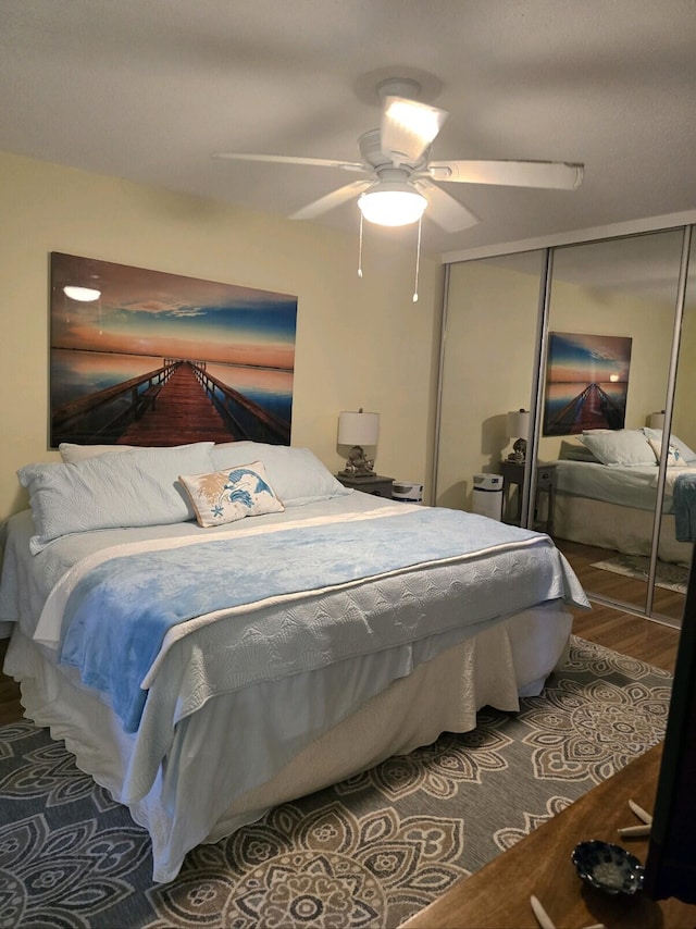 bedroom with hardwood / wood-style flooring, ceiling fan, and a closet