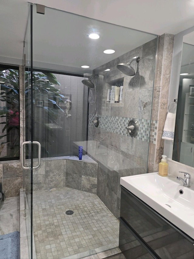 bathroom featuring vanity and a shower with door