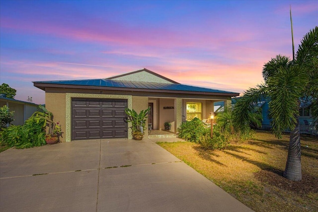 view of front of house featuring a garage and a lawn