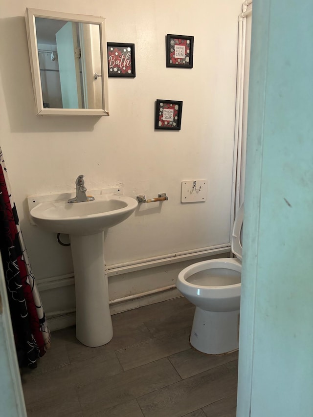 bathroom with toilet and hardwood / wood-style flooring