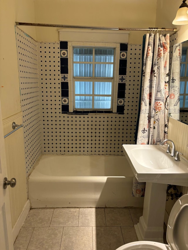 bathroom with toilet, shower / tub combo, and tile patterned floors