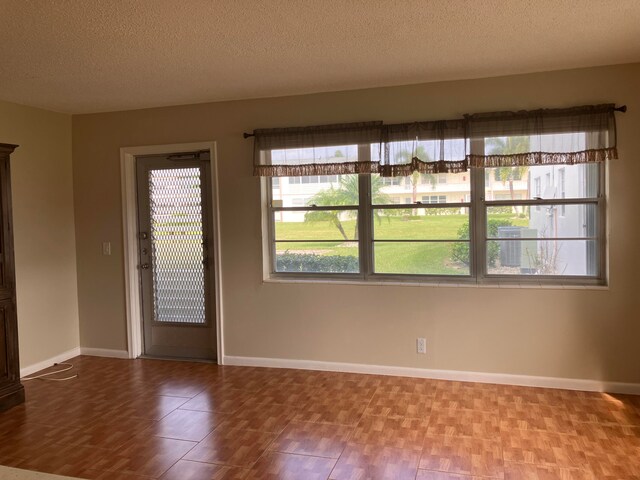 unfurnished room with hardwood / wood-style floors and a textured ceiling