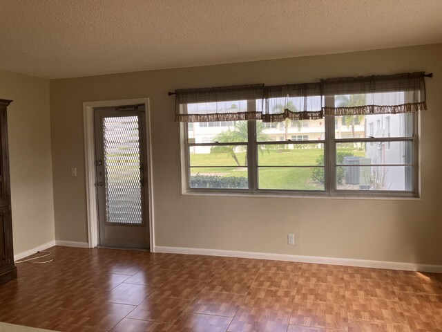 226 Camden J, West Palm Beach, FL 33417 - unfurnished room with a textured ceiling, baseboards, and wood finished floors