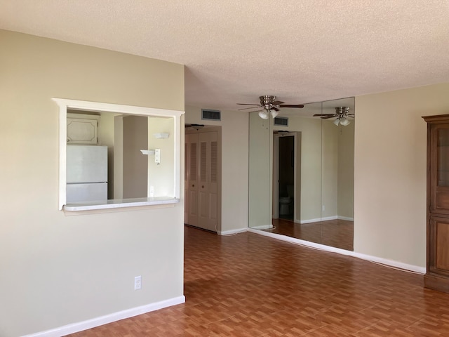 empty room with a textured ceiling and ceiling fan