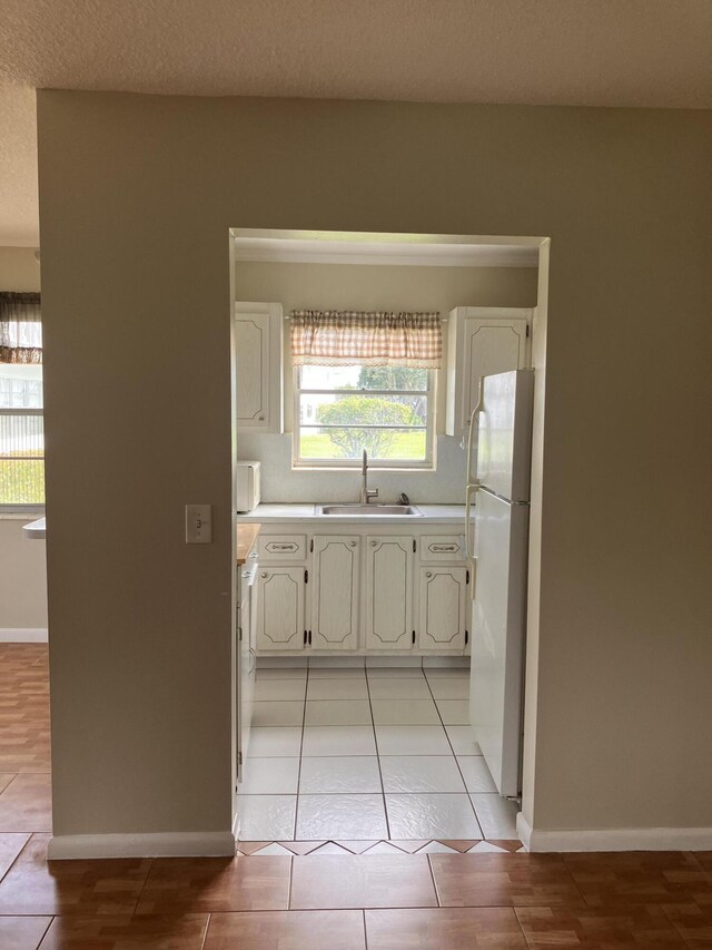 226 Camden J, West Palm Beach, FL 33417 - kitchen featuring white appliances, a sink, light countertops, white cabinetry, and baseboards