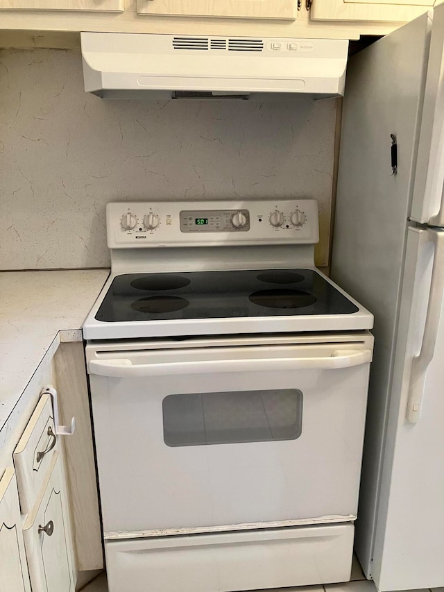 kitchen featuring range hood and white appliances