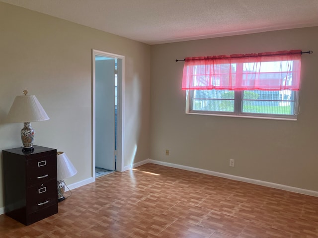 spare room featuring a textured ceiling and a healthy amount of sunlight