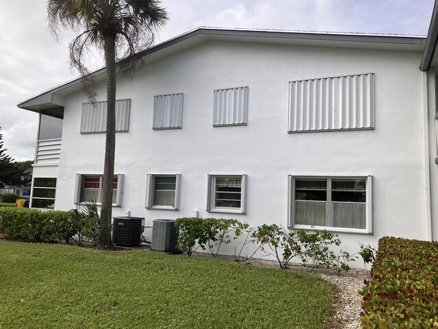 226 Camden J, West Palm Beach, FL 33417 - view of home's exterior featuring stucco siding, central air condition unit, and a lawn