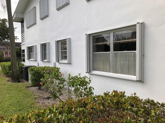 226 Camden J, West Palm Beach, FL 33417 - view of side of property featuring stucco siding and central AC unit