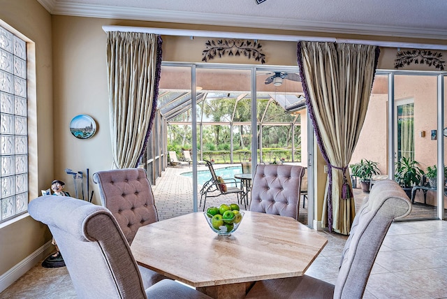 tiled dining area with a textured ceiling, a wealth of natural light, and ornamental molding