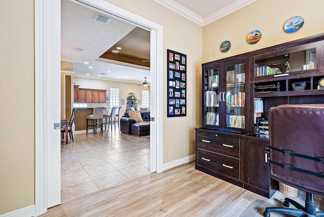 office space with crown molding, ceiling fan, a textured ceiling, and light wood-type flooring