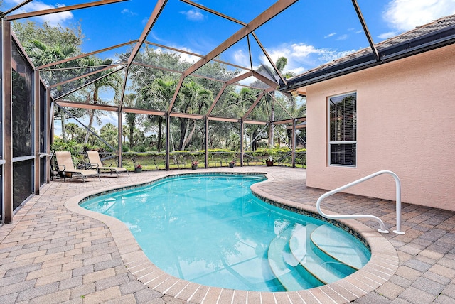 view of pool with a patio and glass enclosure