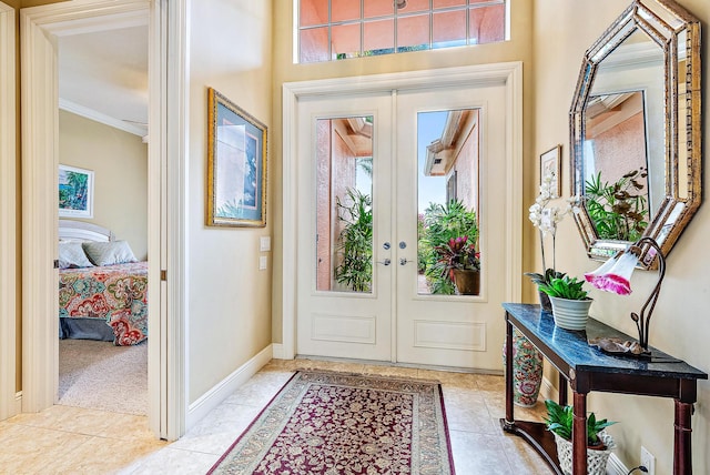 tiled entryway featuring plenty of natural light, french doors, and ornamental molding