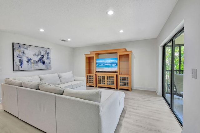 living room with light hardwood / wood-style floors and a textured ceiling