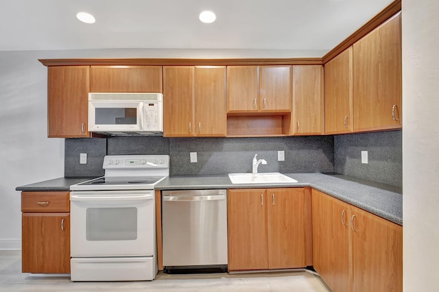 kitchen with tasteful backsplash, white appliances, and sink