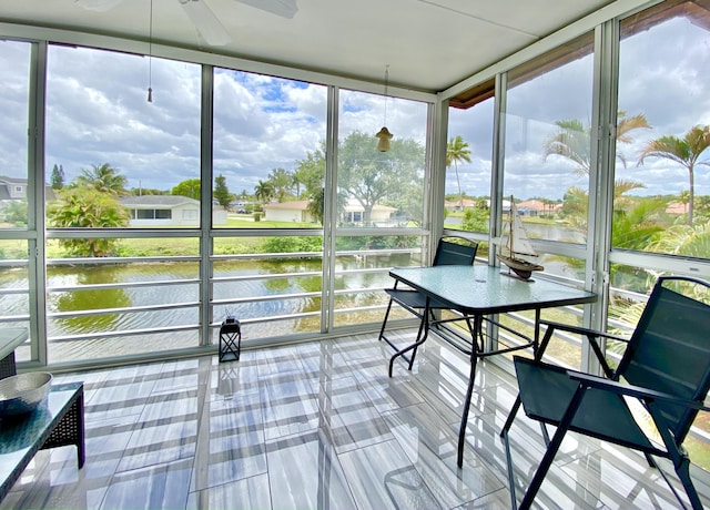 sunroom featuring plenty of natural light, a water view, and ceiling fan