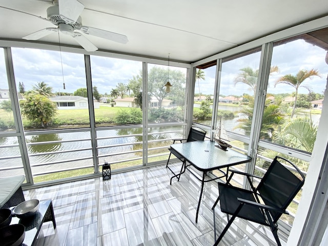 sunroom with a water view and a ceiling fan