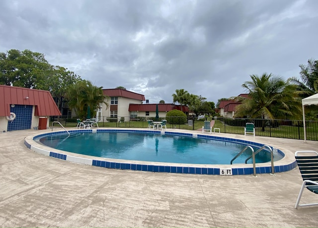 pool featuring a patio area and fence