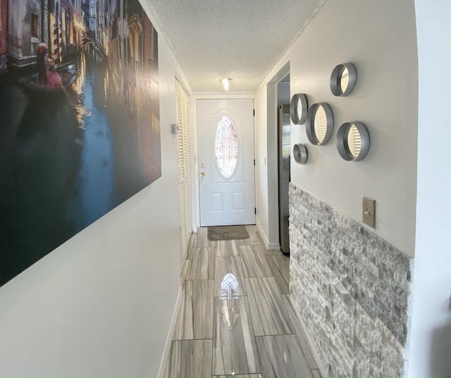 entryway featuring a textured ceiling and baseboards