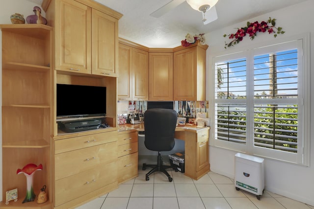 tiled home office with ceiling fan and built in desk