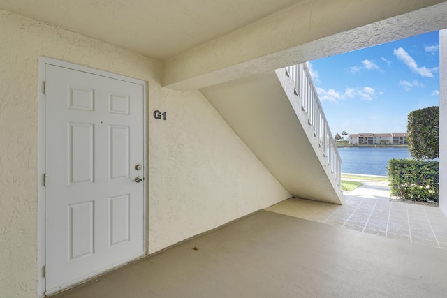 doorway to property with a patio area and a water view