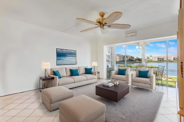 living room with ceiling fan, light tile patterned flooring, and a water view