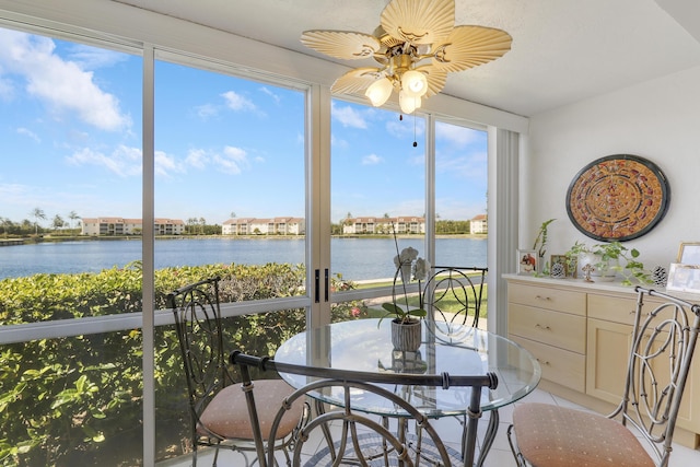 sunroom / solarium with ceiling fan, a healthy amount of sunlight, and a water view