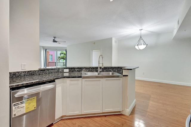 kitchen with sink, white cabinetry, light wood-type flooring, and stainless steel dishwasher