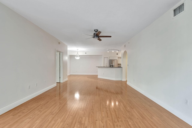 unfurnished living room with ceiling fan and light wood-type flooring