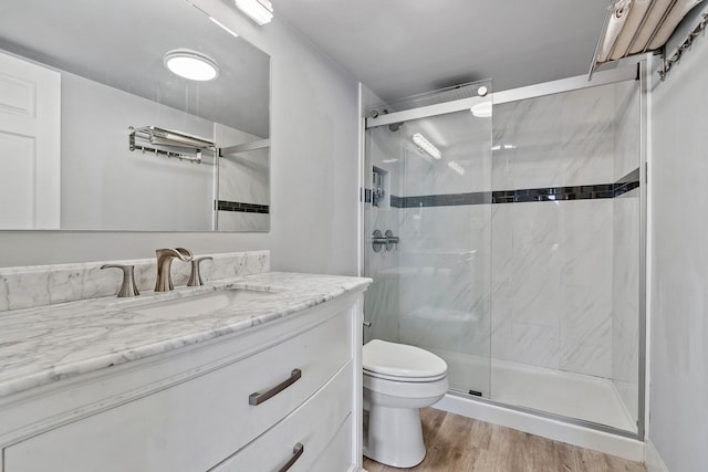 bathroom with walk in shower, oversized vanity, toilet, and hardwood / wood-style flooring